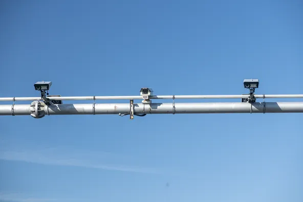Close-up of Bulgaria BGToll vignette enforcement cameras and sensors mounted on overhead gantry pole against clear blue sky